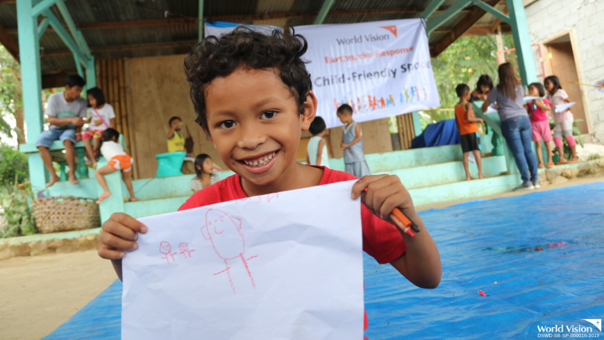 Almer, a 6 year old boy, shows his drawing during a psychosocial activity conducted by World Vision in Kidapawan City
